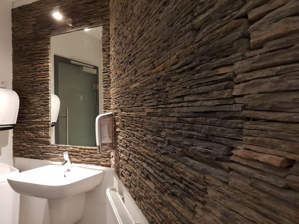 Natursteinwand in einem Gäste-WC.