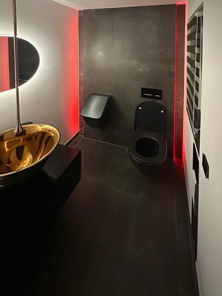 Aufwändig gestaltetes Badezimmer in einem Industriebau, in schwarz und rot.